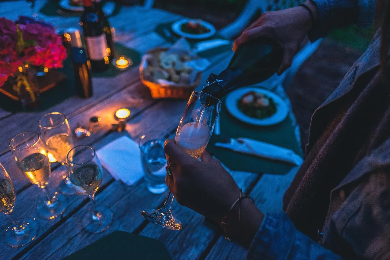 Toast au champagne lors d'un dîner en plein air à la tombée de la nuit
