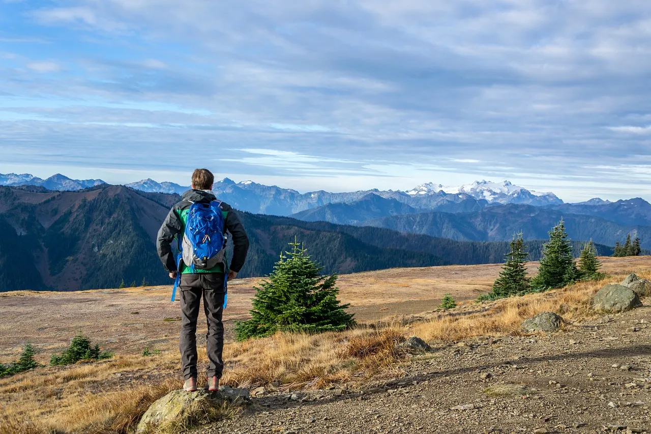 Randonneur sac au dos face aux montagnes enneigées