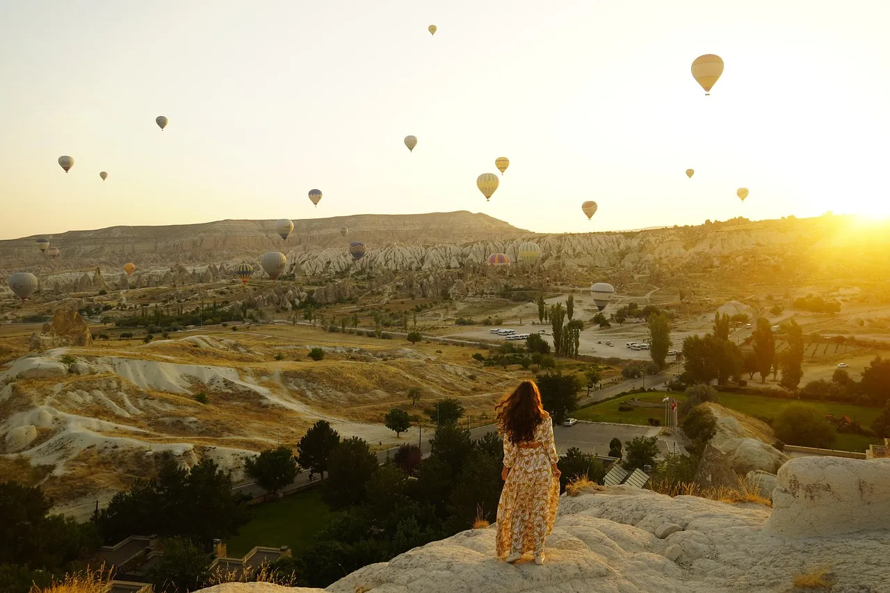 Voyageuse admirant les montgolfières au lever du soleil, en Cappadoce